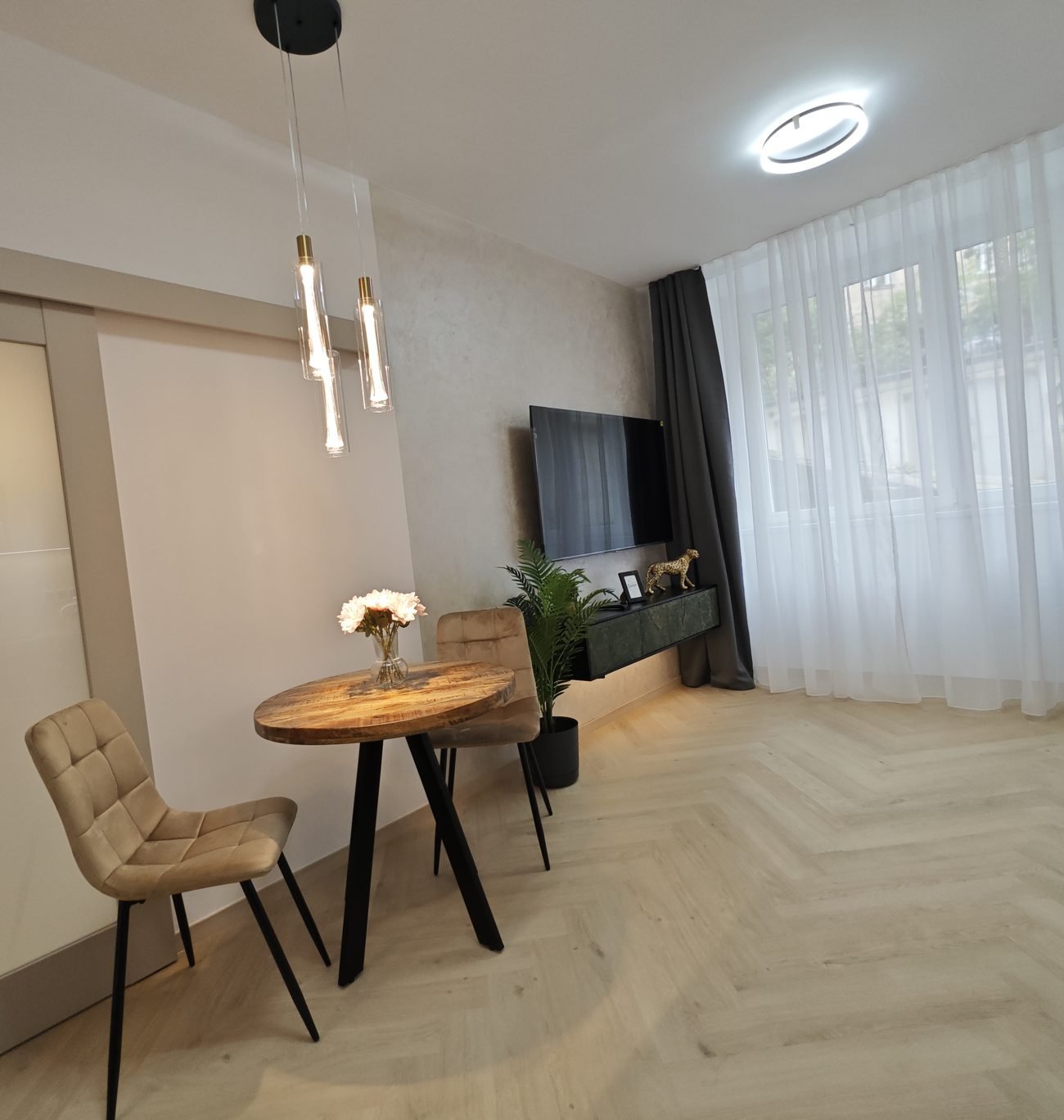 Obývací pokoj připravený k prodeji – jídelní kout, svítidla, rybinová podlaha